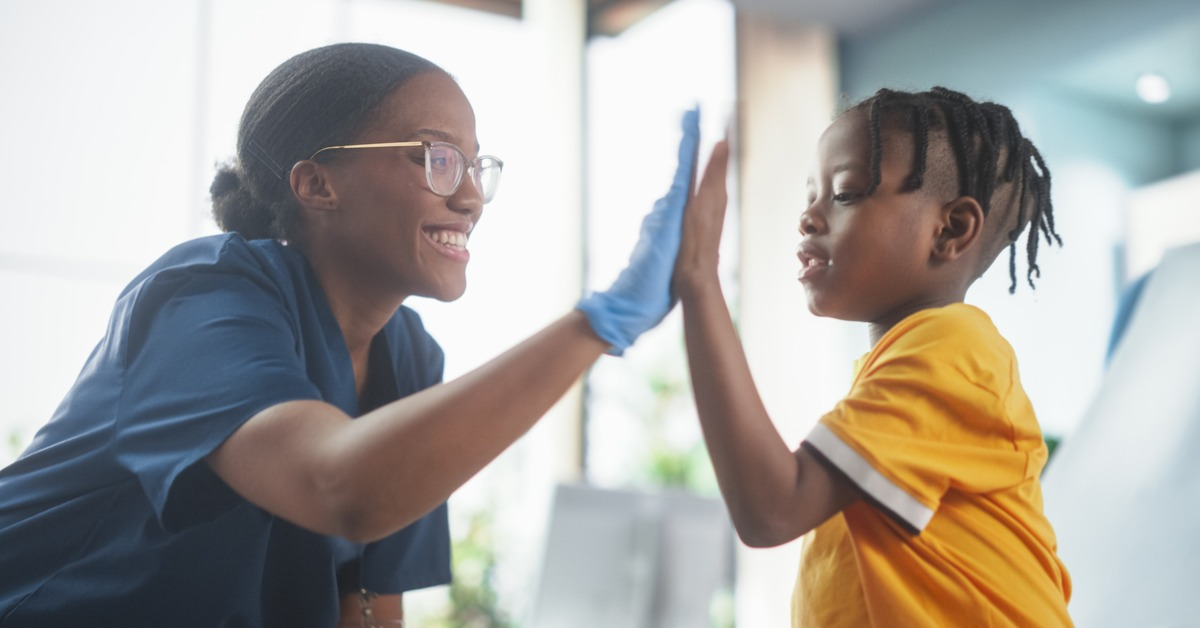 A patient and a nurse high-fiving after a vaccine.