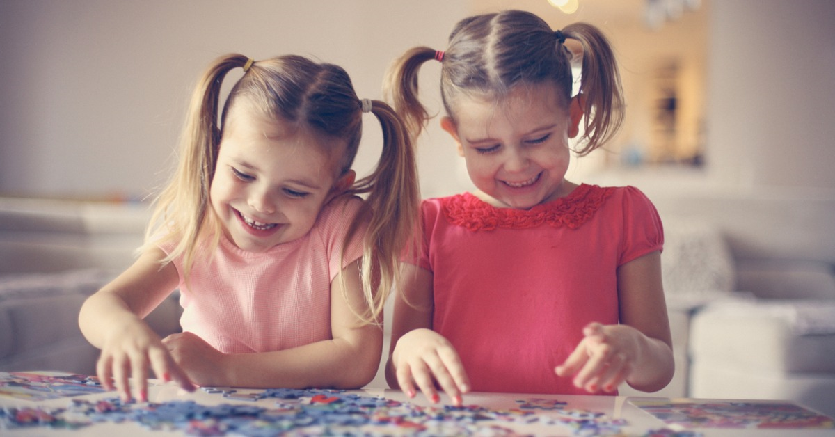 Two girls having fun putting a puzzle togther